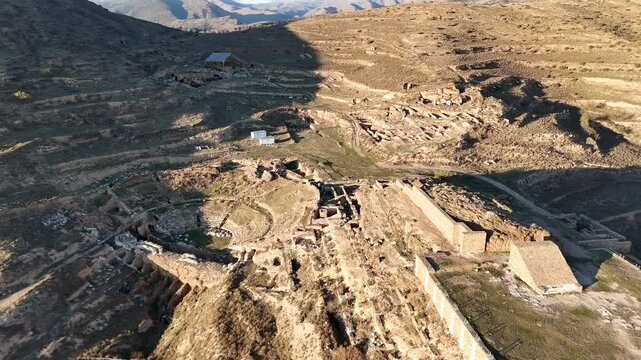 Aerial view of an ancient archaeological site of Augusta Bilbilis in northern Spain with ruins and structures on a hilly landscape.