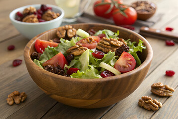 Fresh Green Salad with Walnuts, Cranberries, and Tomatoes in a Wooden Bowl