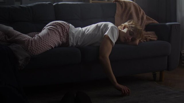 Broken young woman lies on sofa feeling apathy and laziness