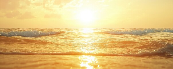 A serene sunset casts golden hues over gentle ocean waves, creating a tranquil atmosphere and reflecting nature's beauty.