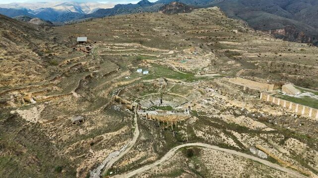Aerial view of an ancient archaeological site of Augusta Bilbilis in northern Spain with ruins and structures on a hilly landscape.