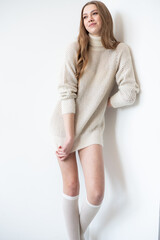 Naklejka premium young beautiful woman in a white sweater and long legs