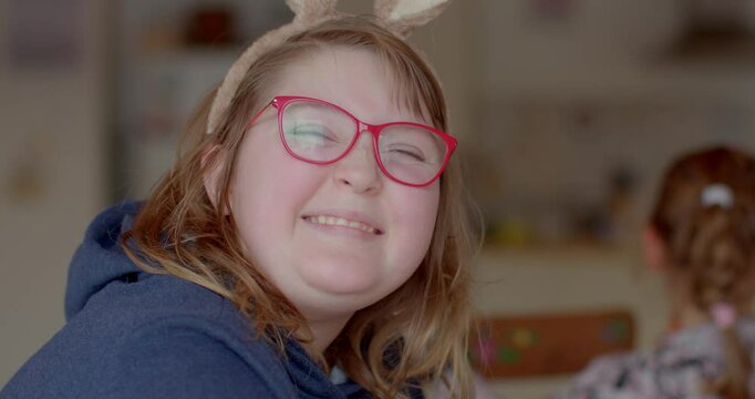 A portrait of a smiling autistic preteen girl, radiating confidence and warmth. She poses naturally, showcasing her unique personality and charm. Easter bunny ears.