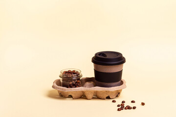 Takeaway coffee. Reusable eco-friendly cup for coffee or tea, coffee beans on beige background. Coffee to go. Place for text.