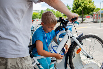 A young child works on a bicycle, fully absorbed in the process of fixing and learning. Perfect for...