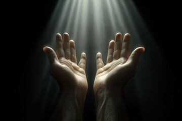 A pair of open hands, palms up in a prayerful or accepting gesture, against a dark background. A beam of light falls from above, illuminating the hands and creating a contrast between light and shadow