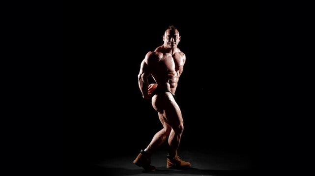The athlete stands in boots, demonstrating not only musculature, but also confidence in his training. Clear muscle lines emphasize a high level of training.