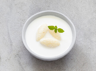 Children Milk soup with cottage cheese quenelles. Decorated with fresh mint. Close up