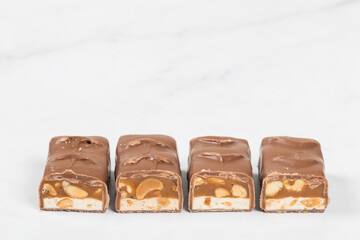 Candy bar. Nougat, caramel with peanuts, in milk chocolat. Copy space