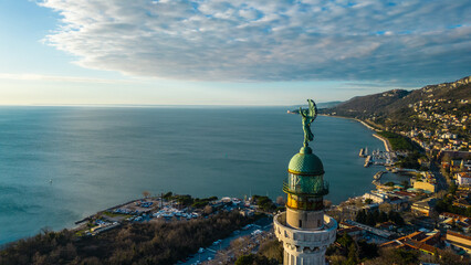 Plakat A breathtaking aerial drone view of the Faro della Vittoria (Victory Lighthouse) in Trieste, Italy. This iconic lighthouse, standing at 68 meters tall, is a symbol of victory
