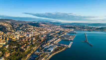 A breathtaking aerial drone view of the Faro della Vittoria (Victory Lighthouse) in Trieste, Italy. This iconic lighthouse, standing at 68 meters tall, is a symbol of victory