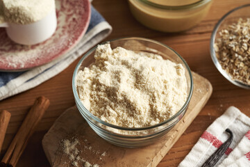 Whey protein powder, oat flakes, sesame tahini, cinnamon and vanilla - ingredients for homemade no-bake protein bars