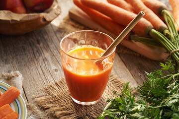 A glass of fresh carrot juice with ecological bamboo straw
