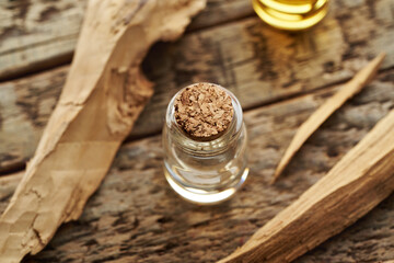 Essential oil bottle with pieces of white sandalwood