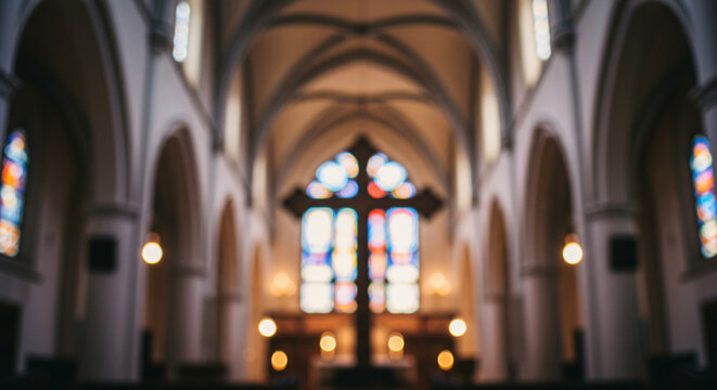 Blurred cathedral interior with gothic arches and stained glass windows creating atmospheric religious architecture background perfect for spiritual themes.