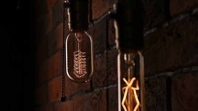Two light bulbs hanging on the wall. Power outages. Flickering lamps. Edison lamp. Antique retro style. Power outages during a hurricane, cataclysm, experiment, bad wiring.