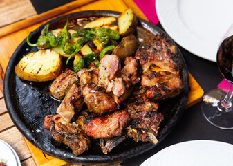 hearty dinner was served for two persons of grilled beef tenderloin with potatoes and fried peppers served in cast-iron frying pan