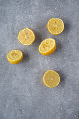 Leftover lemon peels after juicing on a gray background.