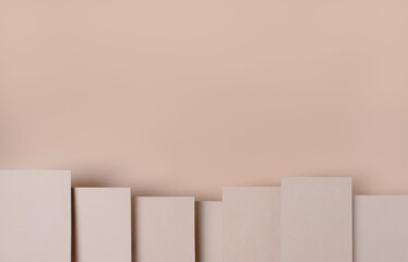 rectangular blank kraft cardboard cards, on different levels, on a beige background, top view, copy space, mock-up