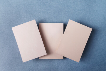 rectangular kraft cardboard, at different levels, on blue textured paper, top view, mockup