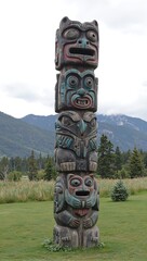 Symmetrical totem pole with wolf raven and bear in meadow