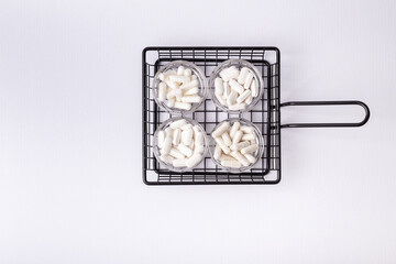 Vitamins and minerals as white capsules in glass jars from above on white background. Minimalistic picture of food supplenents tablets. Healtcare and healthy lifestile. Vitamins for disease prevention