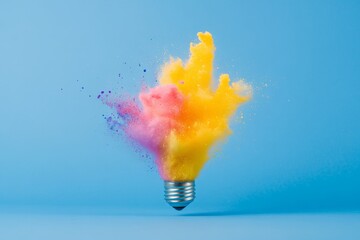 Bright light bulb exploding with colorful powder on blue background