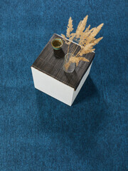 The aesthetic and minimalistic table stands on a colored carpet