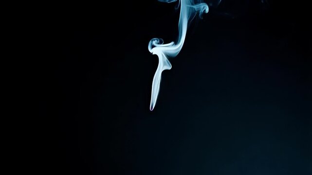 Delicate white smoke rising from burning incense stick, creating mesmerizing swirling patterns against deep black background, revealing ethereal and mysterious atmospheric movement