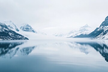 Obraz premium Majestic winter landscape with snow capped mountains and calm reflective lake in Norway during overcast weather. Generative AI