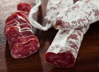 Fuet, traditional spanish dry cured sausage on wooden table