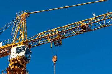 Construction crane lifting equipment against blue sky backdrop