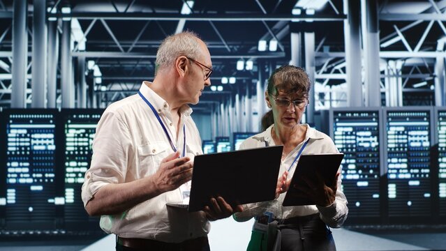 Tech support consultants monitoring energy efficient data center infrastructure. Server parts using renewable sources employed to minimize consumption and reduce overall location carbon footprint