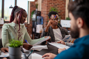 Selective focus on african american businessman and woman reviewing documents during a...