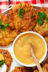 Traditional German potato latkes with applesauce and sour cream.selective focus