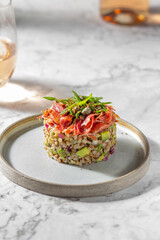 Superfood buckwheat tartare with avocado, capers and red onion, topped with serrano jamon slices