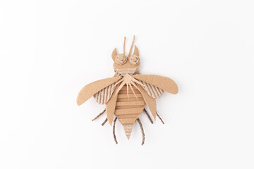 Close up of paper insect made from brown paper on white surface, creative cardboard activities, happy playtime, educational and imaginative handmade crafting project for kids and crafting enthusiasts,