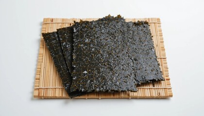 Raw nori sheets placed on a traditional bamboo sushi mat