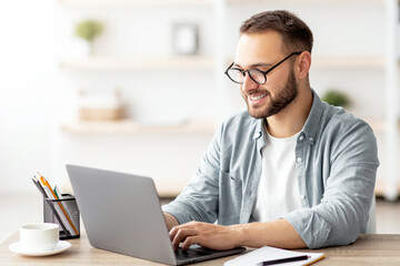 Millennial male tutor with laptop teaching Turkish online from home. Confident young man conducting...