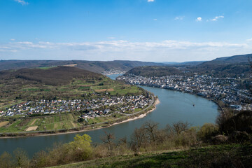 Obraz premium Serene river scene: A charming town nestled in a lush green valley, viewed from an elevated perspective.