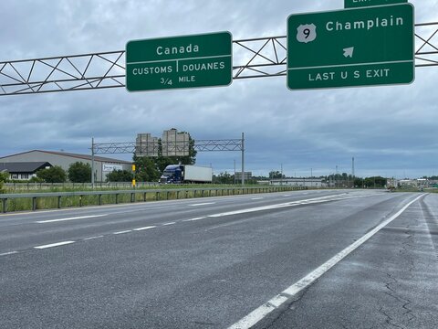 Signs above the highway i Champlain New York advise drivers they are approaching the Canadian border and customs to enter the country