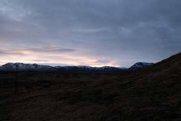 Sunrise over a field with mountains in the background