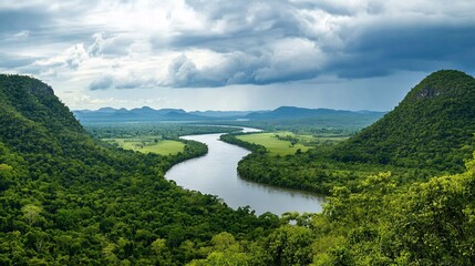Obraz premium Serene River Landscape Surrounded by Green Hills and Dramatic Sky