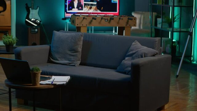 Cozy modern apartment decorated with neon lights and a big tv, home theatre and setup for a young adult. Empty loft studio illuminated and equipped with electronics, comfortable space.