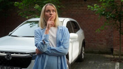 Pensive contemplative Caucasian woman buyer thinking in city pondering driver girl businesswoman...