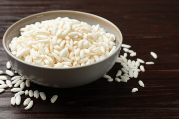 Puffed rice in bowl on wooden table, closeup