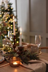 Christmas place setting with festive decor on wooden table in room