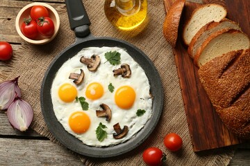 Tasty fried eggs with mushrooms and parsley served on wooden table, flat lay