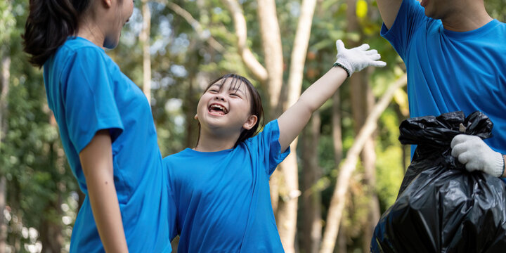 Joyful family volunteers celebrating after collecting garbage in a park, fostering community spirit and environmental responsibility.