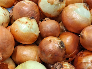 Top view lot of fresh big yellow onions with peel at the grocery.